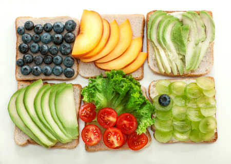 sandwiches with fruits and vegetables lie on a white backgroundの写真素材