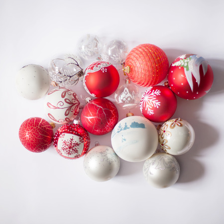 Red and white Christmas balls on a white background with different pictures on them. Christmas and New Year conceptの写真素材