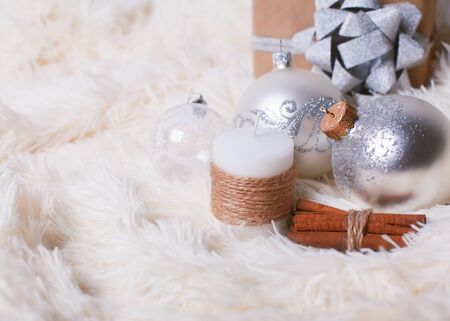 Christmas concept - Christmas balls, decorative candle, gift on a fur backgroundの写真素材
