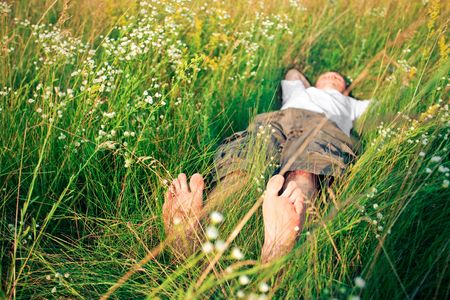 young adult man in spring grassの写真素材