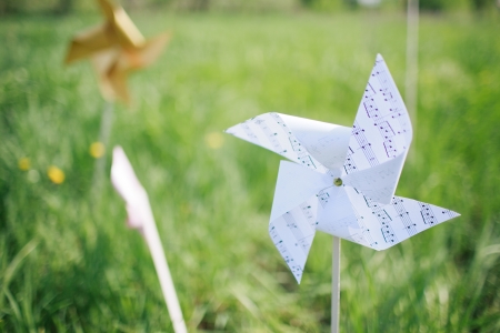 paper windmill in green grass fieldの写真素材