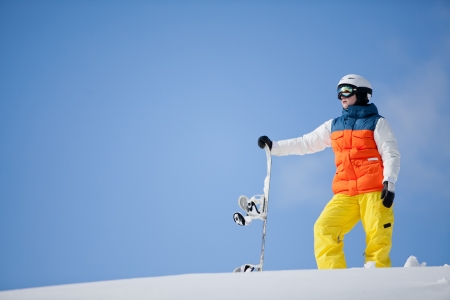 female snowboarder against sun and skyの写真素材