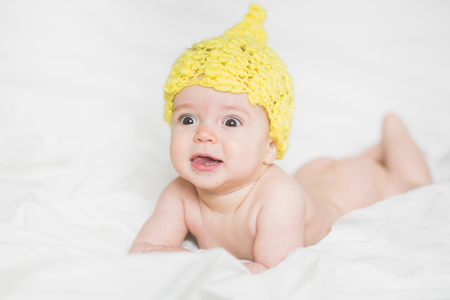 adorable newborn baby on a bedの写真素材