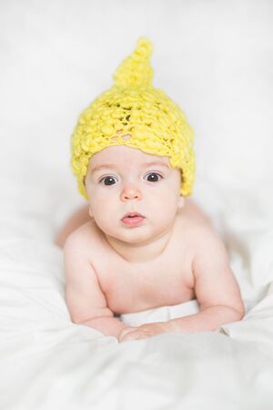 adorable newborn baby on a bedの写真素材