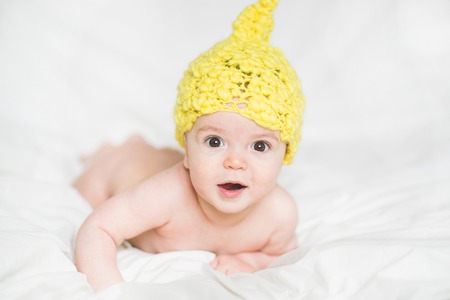 adorable newborn baby on a bedの写真素材