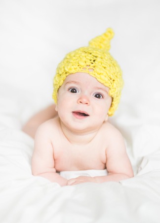 adorable newborn baby on a bedの写真素材