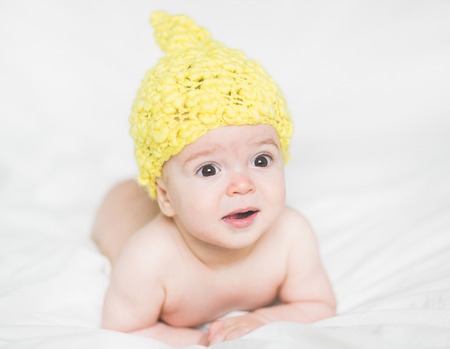 adorable newborn baby on a bedの写真素材