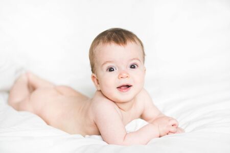 adorable newborn baby on a bedの写真素材