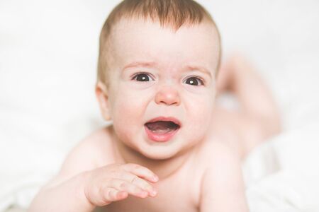 adorable newborn baby on a bedの写真素材