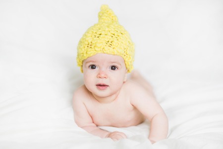 adorable newborn baby on a bedの写真素材