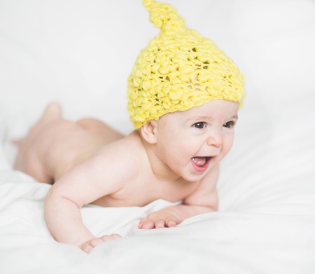 adorable newborn baby on a bedの写真素材