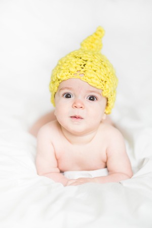 adorable newborn baby on a bedの写真素材