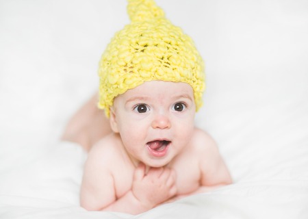 adorable newborn baby on a bedの写真素材