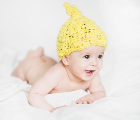 adorable newborn baby on a bedの写真素材