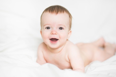 adorable newborn baby on a bedの写真素材