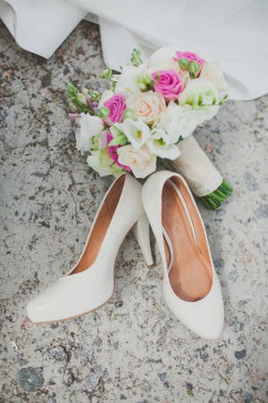 Elegant white wedding shoes on the tableの写真素材