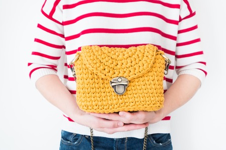 Close up photo of woman bag in hands of fashionable woman. Elegant outfit. Female fashion concept