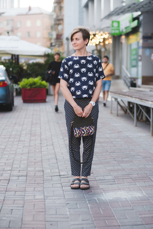 Outdoor full body portrait of young beautiful fashionable woman with small khaki bagの写真素材
