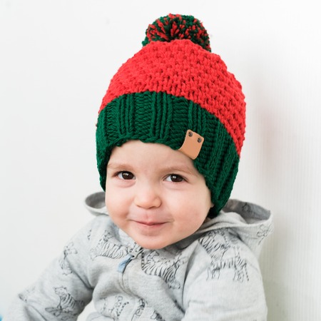 cute kid in knitted Elf red-green hatの写真素材