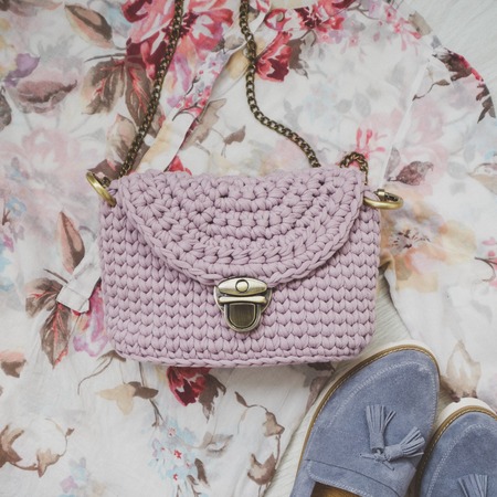 Fashion handmade textile female handbag on flower backgroundの写真素材