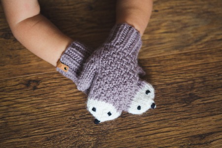 Child hands in winter hedgehog mittensの写真素材