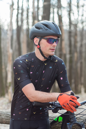 male athlete mountainbiker with bicycle along a forest trail. in forest mistの写真素材