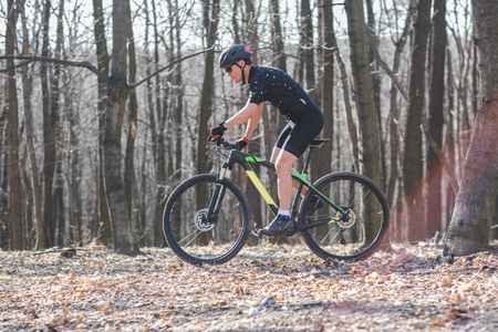 male athlete mountainbiker with bicycle along a forest trail. in forest mistの写真素材