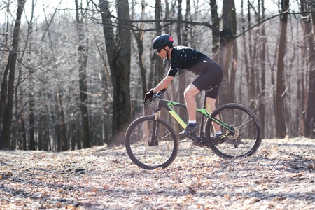 male athlete mountainbiker with bicycle along a forest trail. in forest mistの写真素材