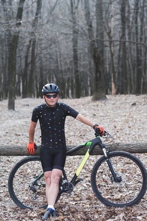 male athlete mountainbiker with bicycle along a forest trail. in forest mistの写真素材