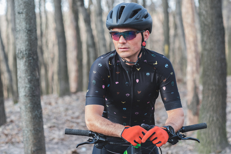male athlete mountainbiker with bicycle along a forest trail. in forest mistの写真素材
