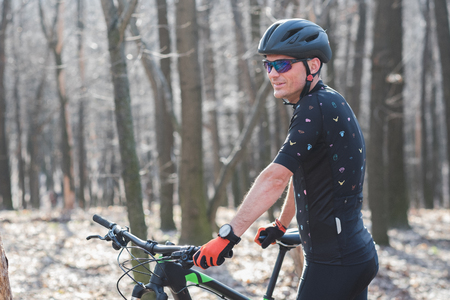 male athlete mountainbiker with bicycle along a forest trail. in forest mistの写真素材