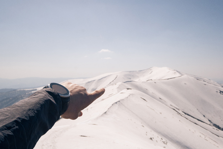 Runner checking progress on smart watch. Fit male runner exercise training and jumping outdoors in beautiful mountain nature landscapeの写真素材