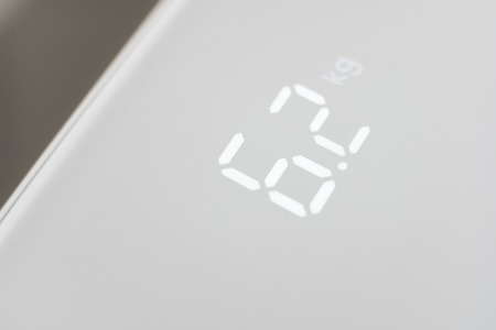 digital display of a weight scale closeup on a white backgroundの写真素材