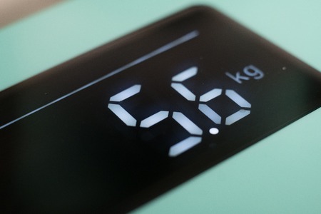 digital display of a weight scale closeup on a white backgroundの写真素材