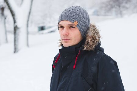 Cool man in winter fashion. Wearing scarf and knit hatの写真素材