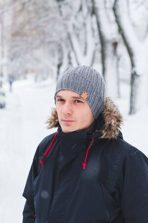 Cool man in winter fashion. Wearing scarf and knit hatの写真素材