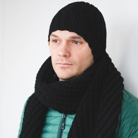 Cool man in winter fashion. Wearing scarf and knit hatの写真素材