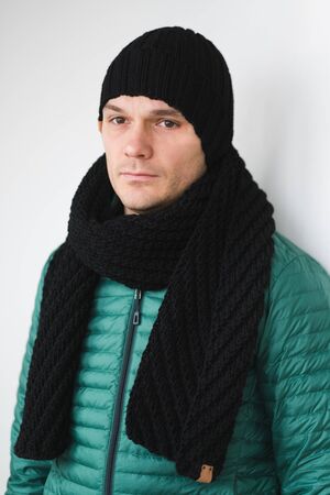 Cool man in winter fashion. Wearing scarf and knit hatの写真素材