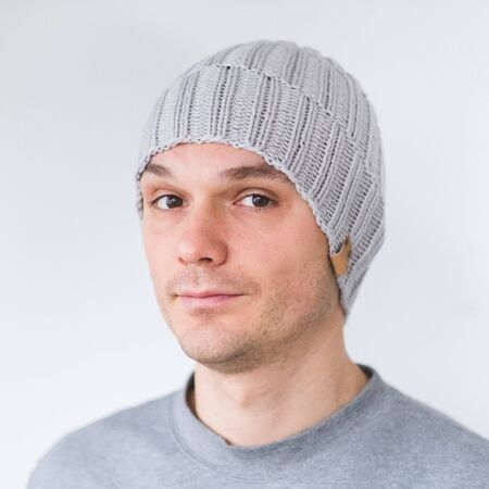 Cool man in winter fashion. Wearing scarf and knit hatの写真素材
