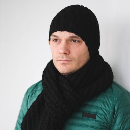 Cool man in winter fashion. Wearing scarf and knit hatの写真素材