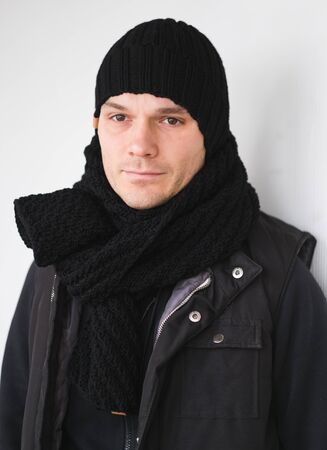 Cool man in winter fashion. Wearing scarf and knit hatの写真素材