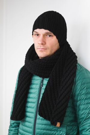 Cool man in winter fashion. Wearing scarf and knit hatの写真素材