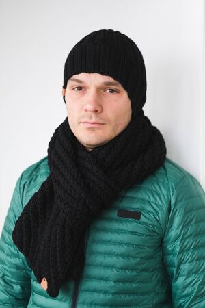 Cool man in winter fashion. Wearing scarf and knit hatの写真素材