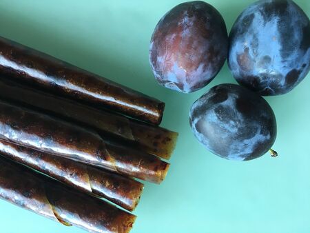 Sweet pureed fruit pastille. Fruit roll-ups homemade on a wooden background. Natural sweets from plum fruits.の写真素材