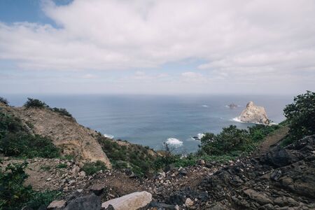Aerial view of tropical beach and turquoise clear ocean water with small waves and palm trees forest in mountains. Tenerife, Spain. Travel tropical conceptの写真素材