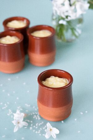 Creamy rice pudding served in a ceramic jar with spring flowers vaseの写真素材