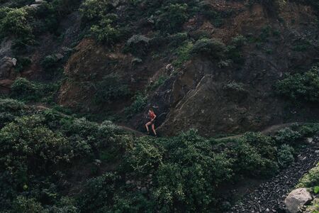 Woman trail running on a mountain path. Runner working out in beautiful nature.の写真素材