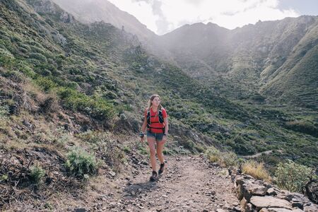 Woman trail running on a mountain pathの写真素材