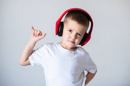 Boy in white t-shirt with headphones isolated on white backgroundの写真素材