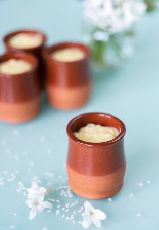 Creamy rice pudding served in a ceramic jar with spring flowers vaseの写真素材